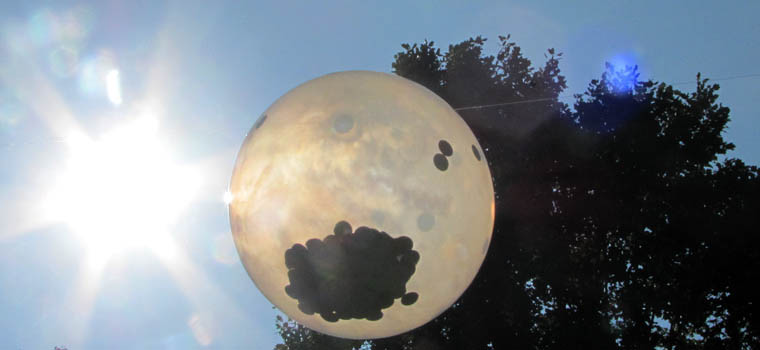 A ballon filled with confettii. pic is looking skyward sun is beaming.