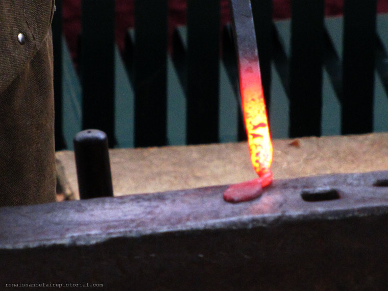 Man hammer metal on an anvil.