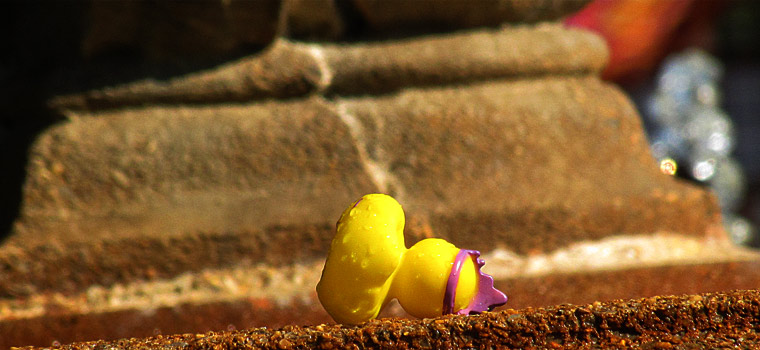 rubber duck fallen on its side at a fountain.