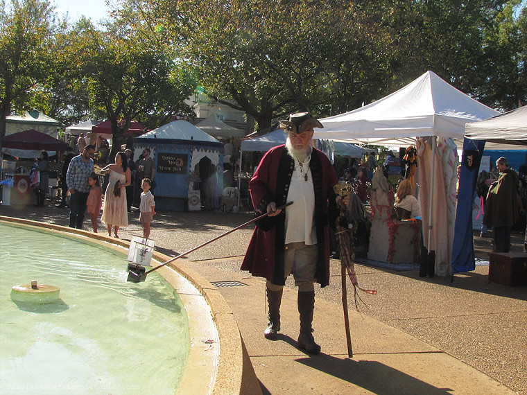 lady in blue hat red beaded necklace.