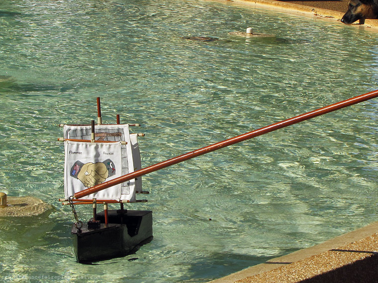 lady in blue hat red beaded necklace.