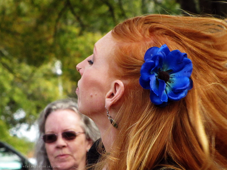 red headed dancer with a blue flower in her hair..