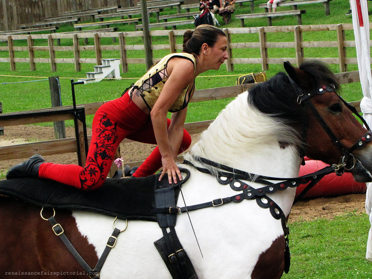 woman crouching while riding a horse