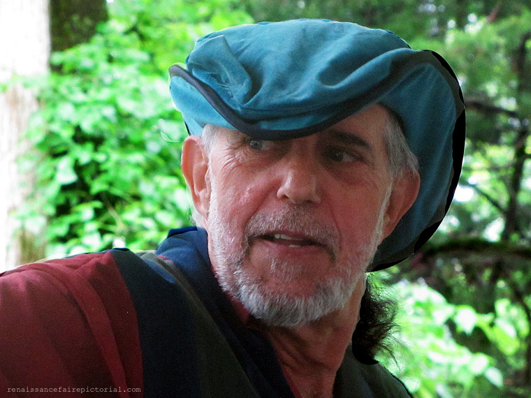 Man in teal hat, red and blue shirt