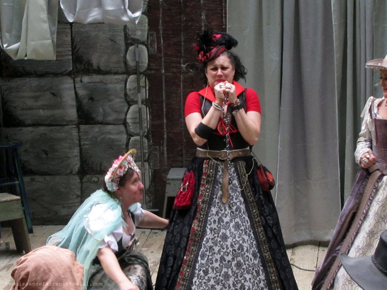 Ladied in regal dresses. one is crouching acting like a bird,  another is looking worried.