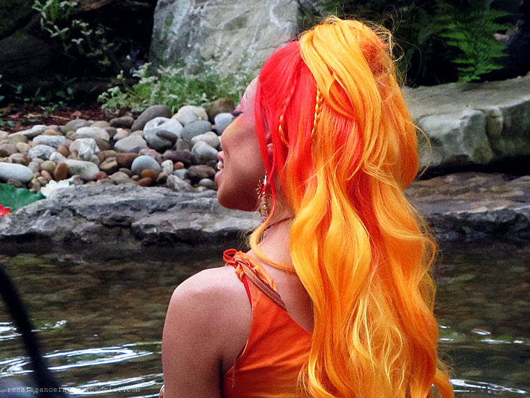 dark skinned mermaid with red and orange hair. 