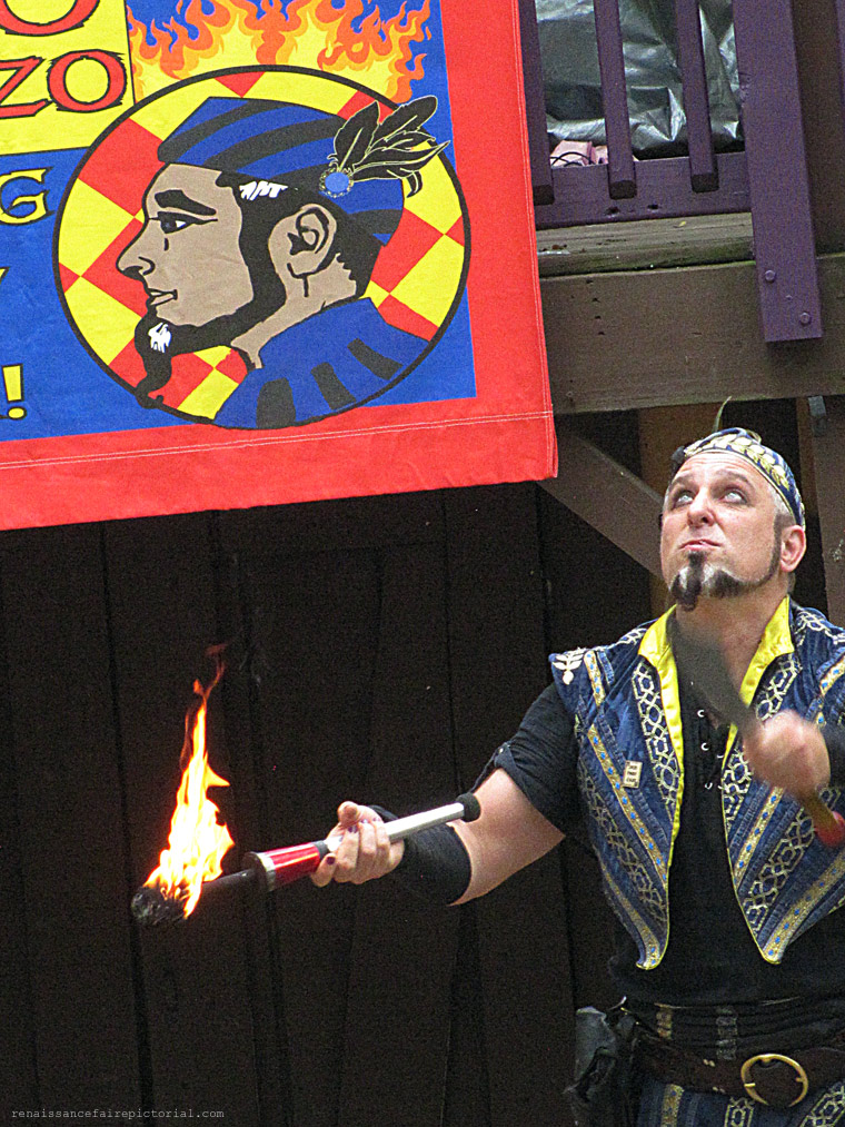 Man juggling flaming torch, machete, and an onion.