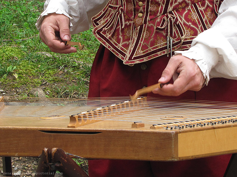 man palying a hammer dulcimir.