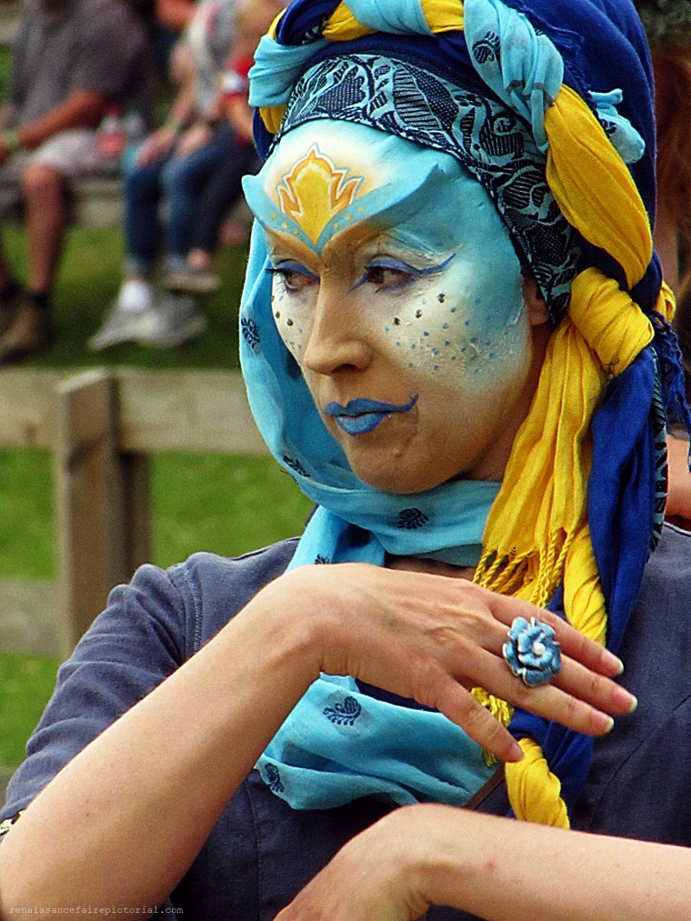 Dancer in blue. she has blue and white face paint. 