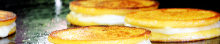 cornbread pancakeson griddle. Stack of two pancakes with cheese between them. 