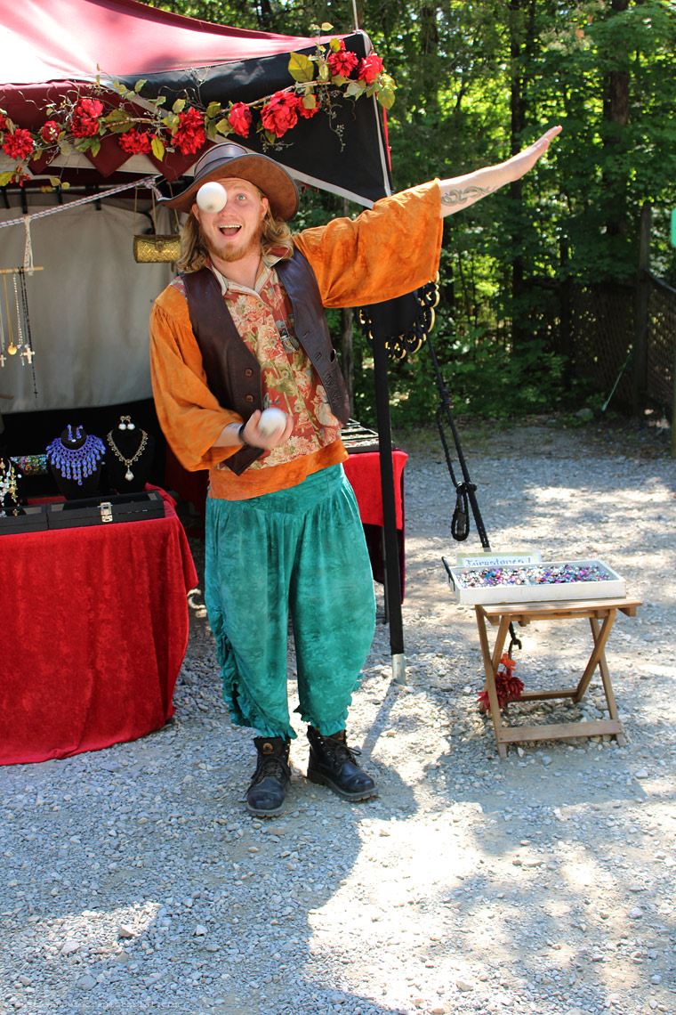 man juggling ball. one is in midair in front of his eye.